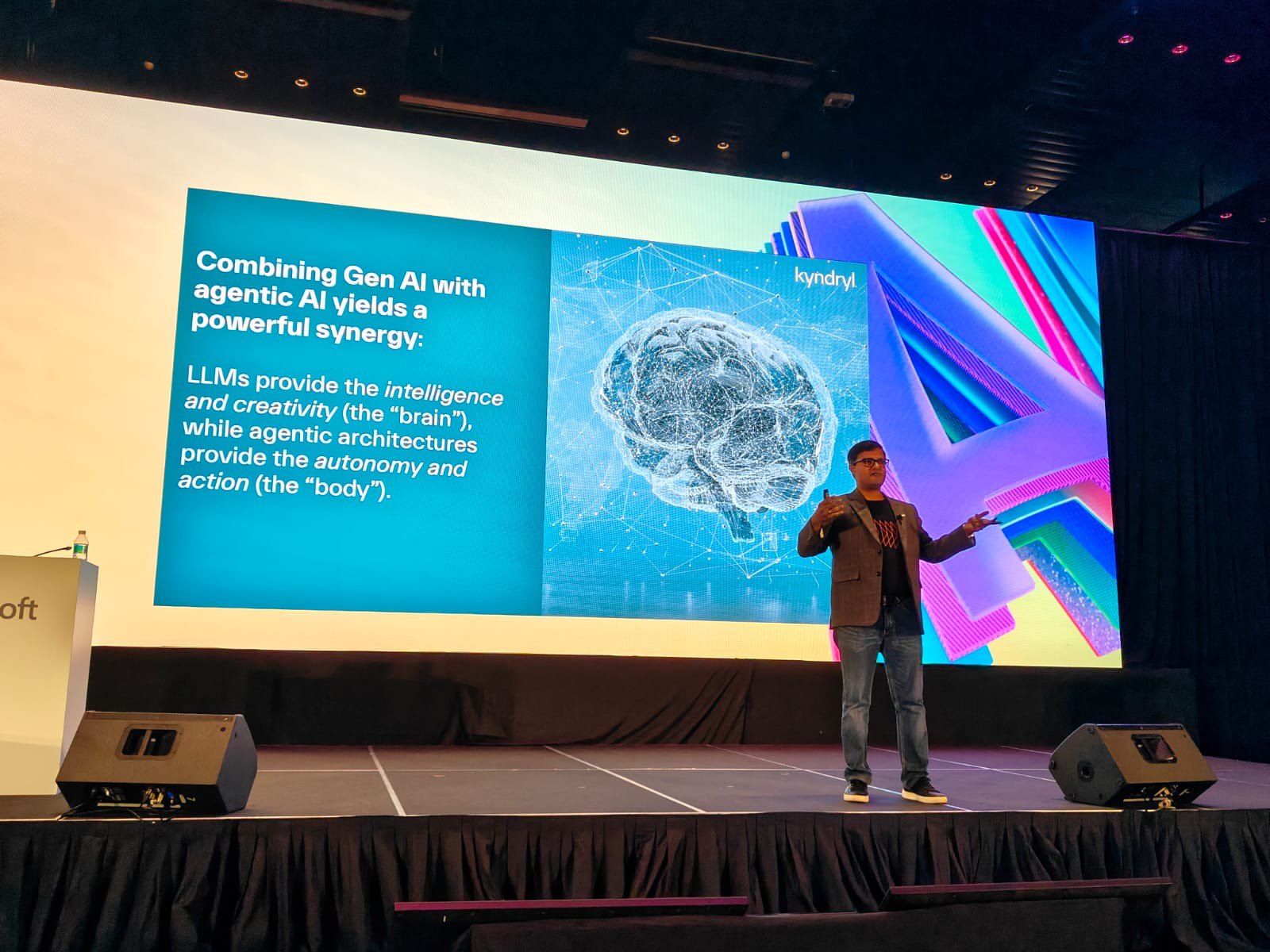 Vishnu Nanduri on a large stage presenting a slide on combining generative AI with agentic AI