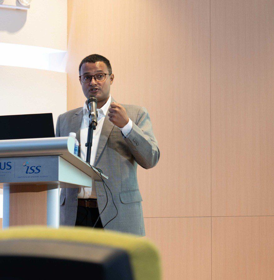 Vishnu Nanduri lecturing at an NUS Institute of Systems Science podium