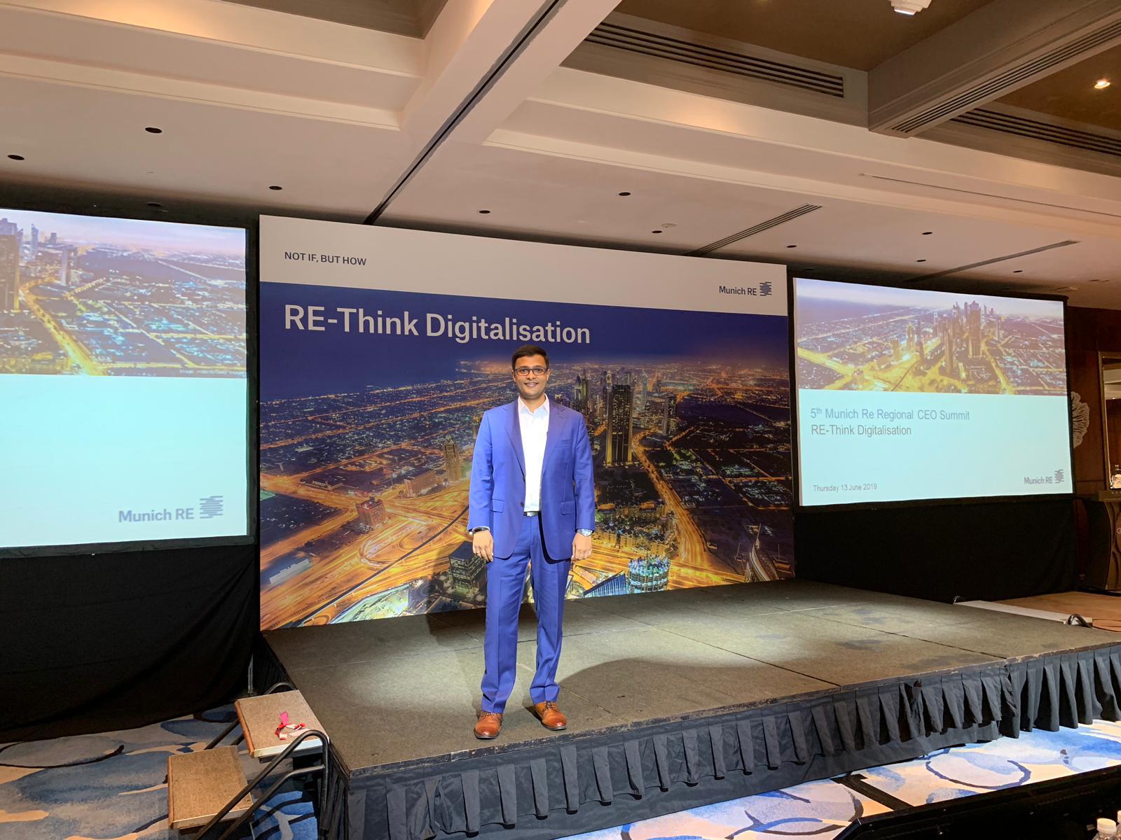 Vishnu Nanduri on stage in front of a Munich Re “RE-Think Digitalisation” backdrop